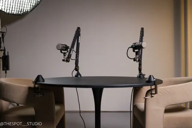 Podcast table with two microphones and softbox lighting in the Garage Room