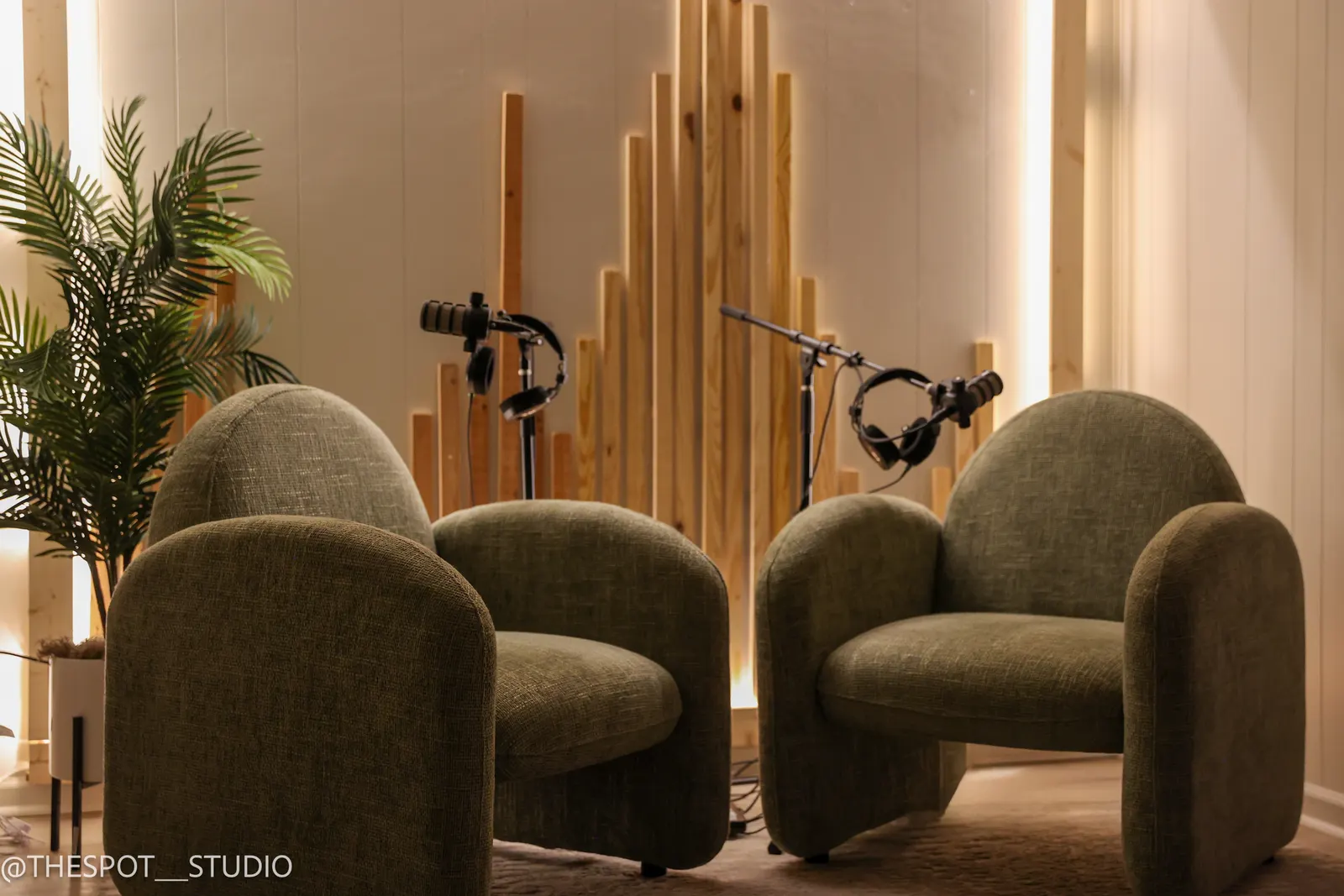 Sage armchairs and wood slat backdrop in the Neutral Room