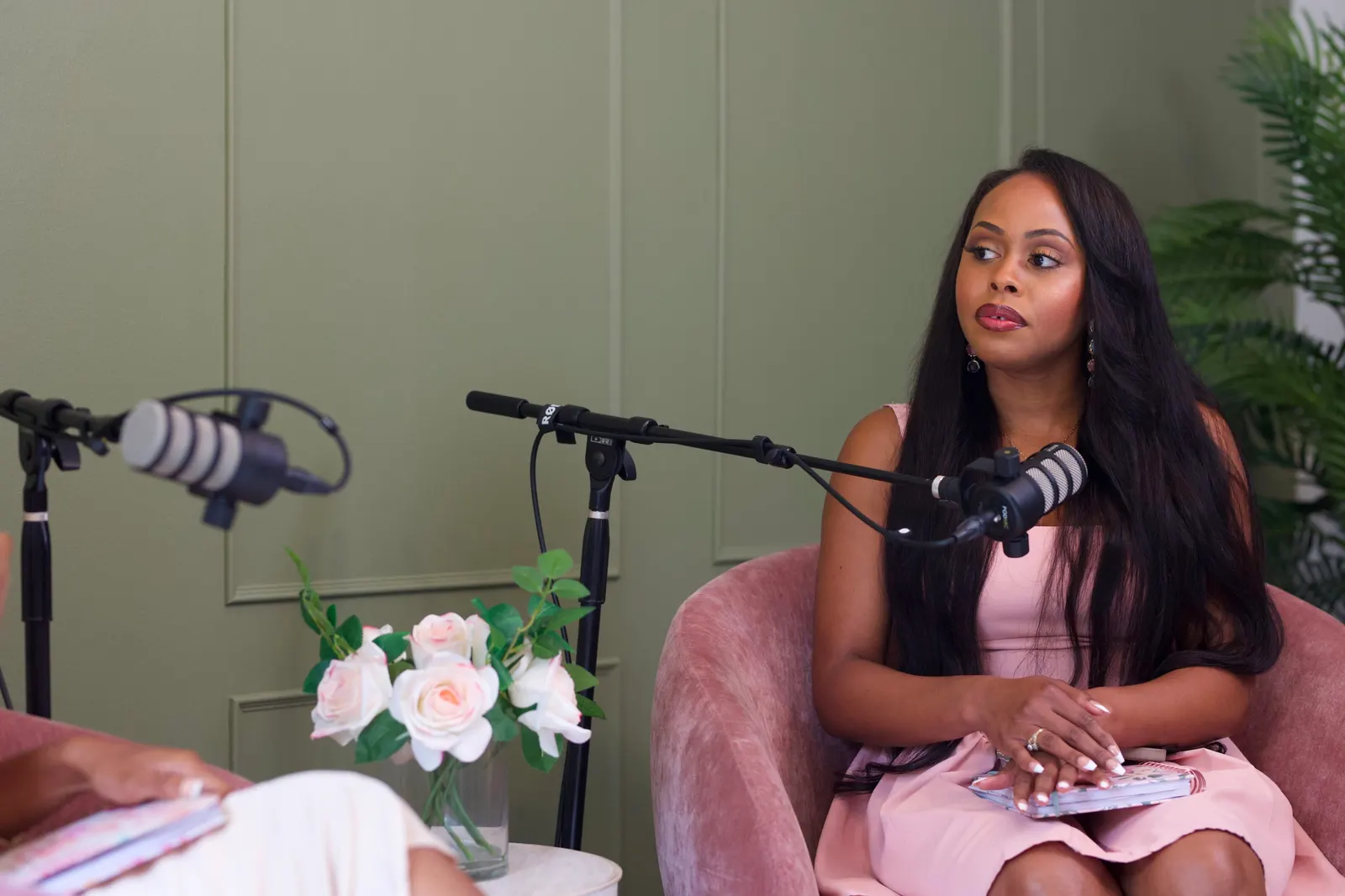 Two guests recording in pink chairs